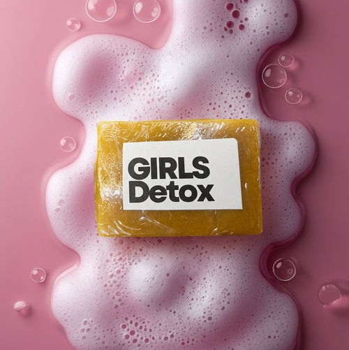 Golden-yellow Girls Detox turmeric soap on pink background with foam and bubbles